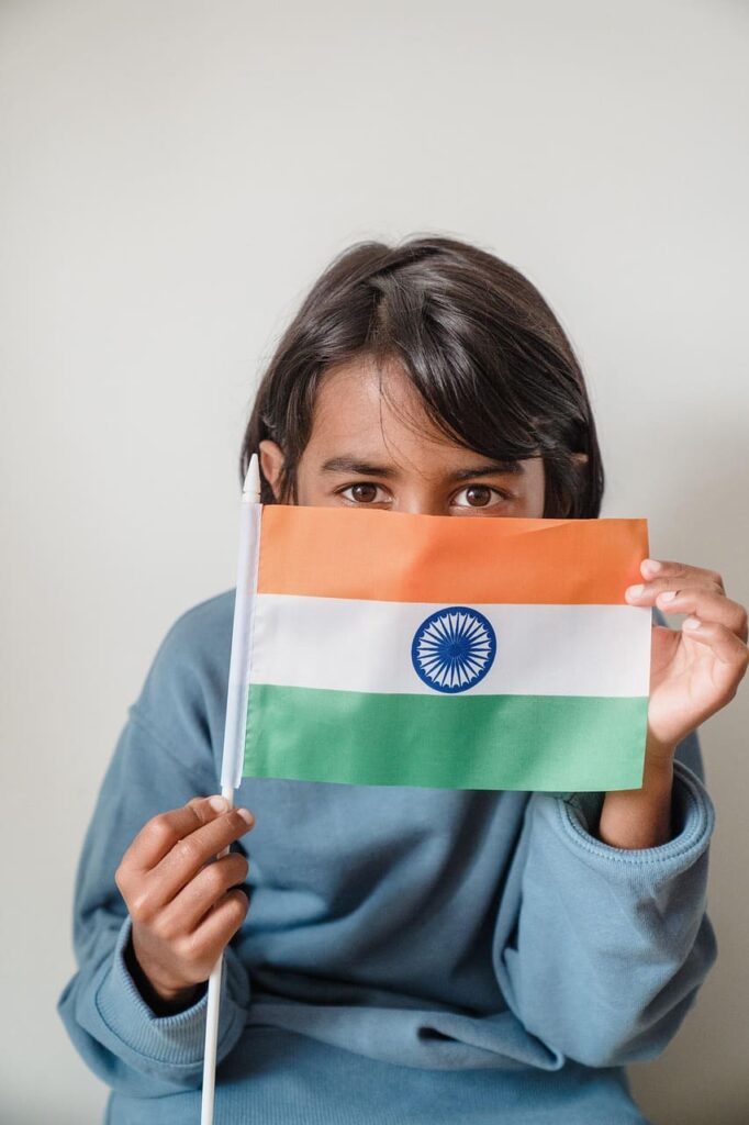small-girl-carrying-India-flag Little girl holding and waving the Indian national flag, celebrating Independence Day with pride and joy.