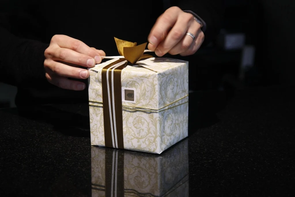 giveaways-by-influencers Hands opening a gift box to reveal the brand-new iPhone 17, perfect for tech giveaways and unboxing content.