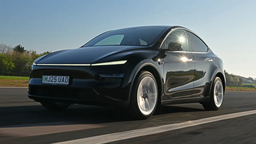 Tesla model Y-16 2025 Tesla Model Y electric SUV parked beside a charging station, symbolizing the rise of EVs in 2025.