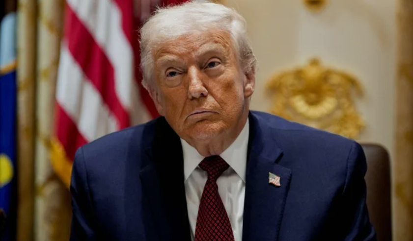 Donald Trump speaking at a rally as European Union flags appear in the background following his criticism of Europe.