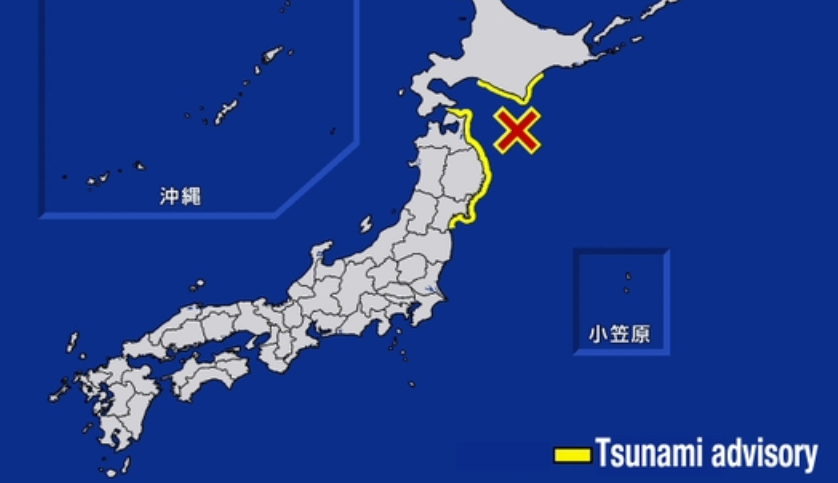 Damaged buildings and cracked roads in a Japanese coastal town following a 6.7-magnitude earthquake.