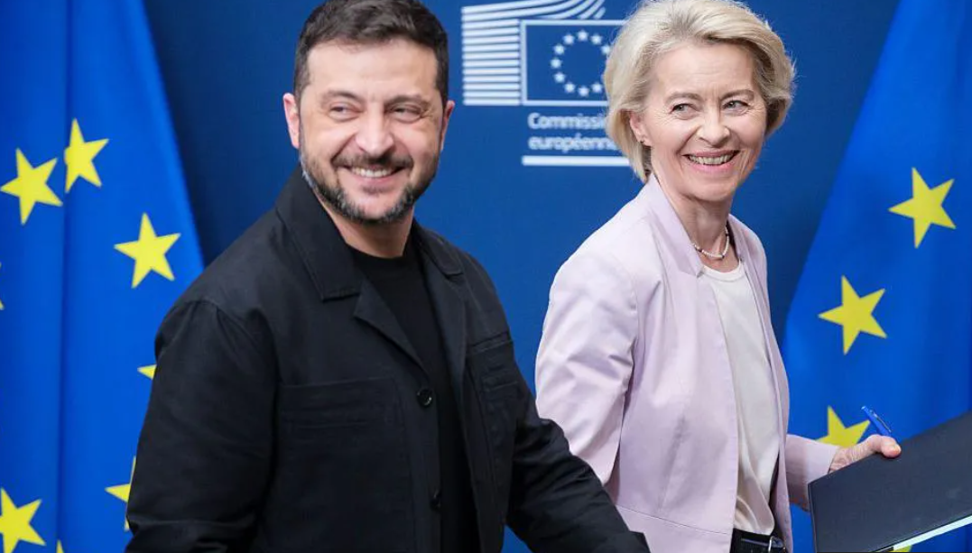 European Union official and Ukrainian leader stand together at an EU headquarters with European flags in the background.