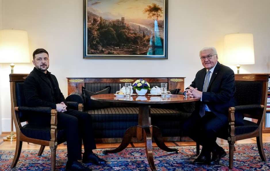 Two senior officials seated across a small table in a formal meeting room, engaged in diplomatic talks as part of ongoing Ukraine peace negotiations in Berlin.